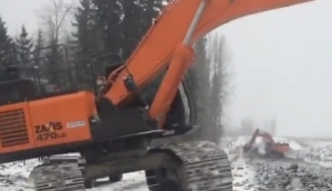 Mit Bagger über ein Rohr steigen
