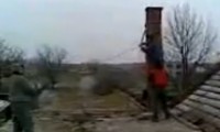 Vier Arbeiter reissen einen Schornstein ab