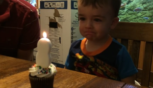 Junge hat Probleme die Kerze auszupusten Junge hat Probleme die Kerze auszupusten