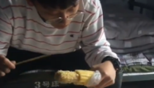 Mais essen mit Stäbchen