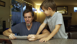 Vater macht Sandwich nach Anleitung seiner Kinder